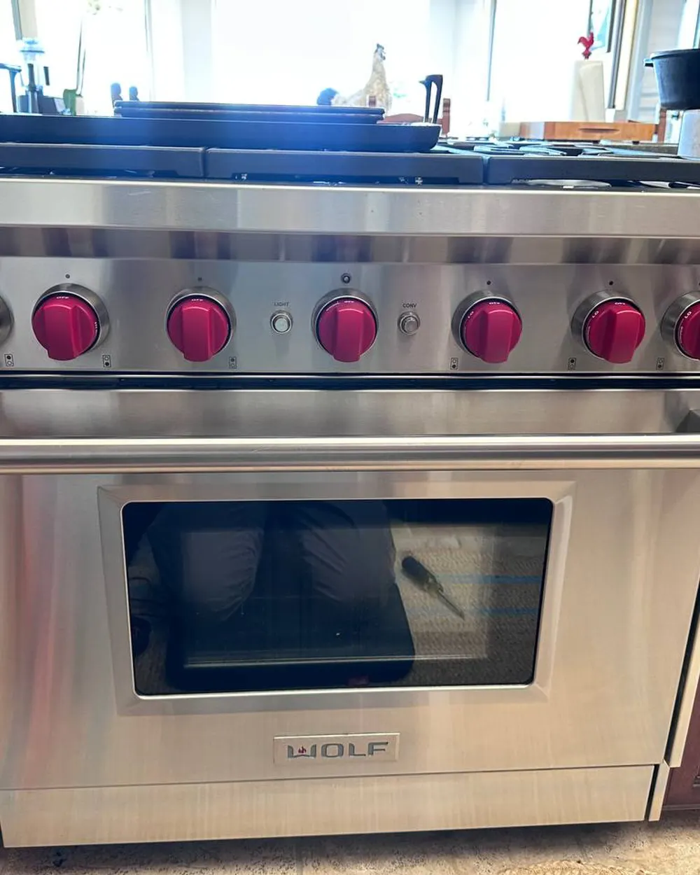 Wolf stainless range with its signature red knobs, serviced in North County